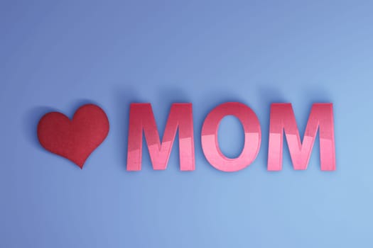 Mom text with red heart over blue background. Mother's day concept.