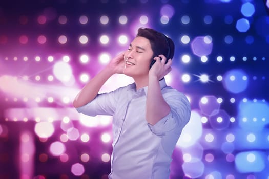 Young asian man listening music headphones with relax over blurred light background