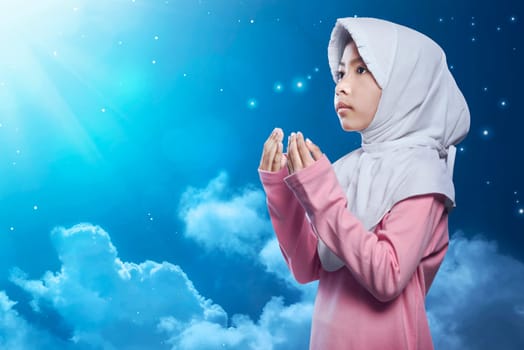 Little asian muslim kid in hijab pray with night scene background