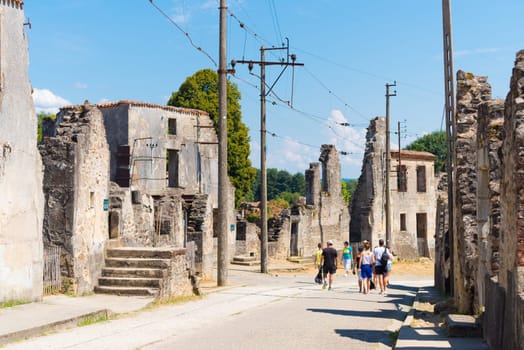 ORADOUR-SUR-GLANE, FRANCE - AUGUST 15, 2016: Tourists between the ruins of the by the nazis destroyed french village in WW2