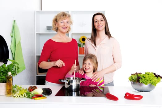 woman with daughter and grandchild together cooking together in the kitchen