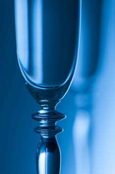 Upper part of a champagne glass in front of a brightness background toneed blue.