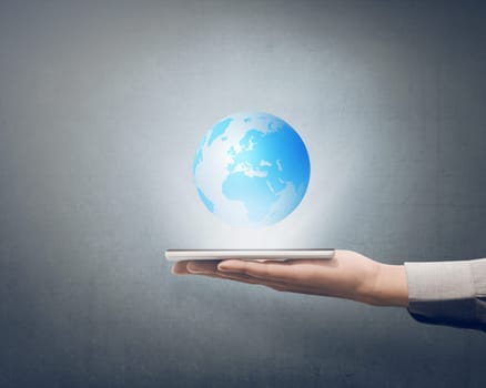 Businessman holding smart phone in his hand with globe on it over grey background