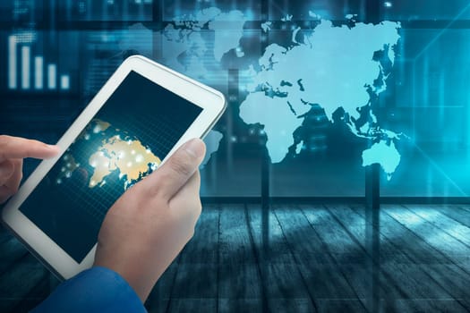 Businessman working on futuristic tablet computer with virtual world map on background