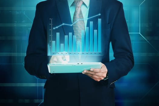 Businessman using the tablet with financial chart hologram against digital background