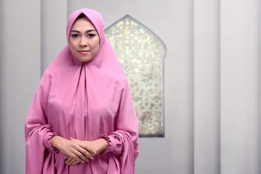 Beautiful asian muslim woman with smiley face standing in the mosque