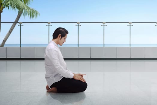Young asian muslim man kneeling and praying on the terrace mosque