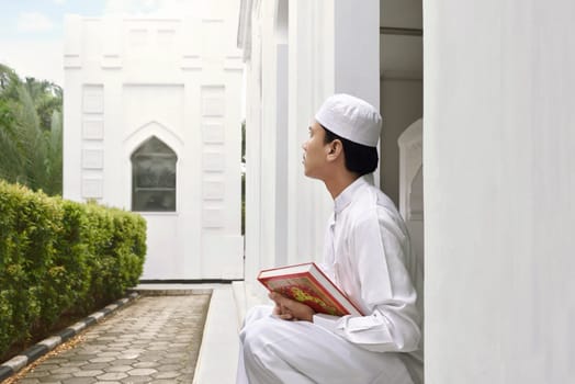 Portrait of asian muslim man holding quran in the mosque