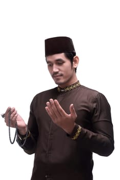 Religious asian muslim man with cap praying isolated over white background