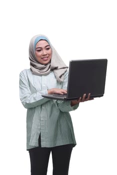 Beautiful asian muslim woman holding while typing on laptop isolated over white background