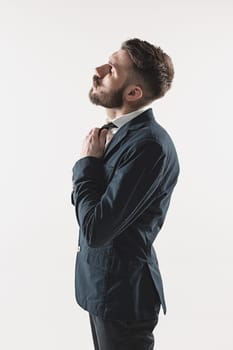 Portrait of stylish handsome young man standing at studio against white. Man wearing jacket