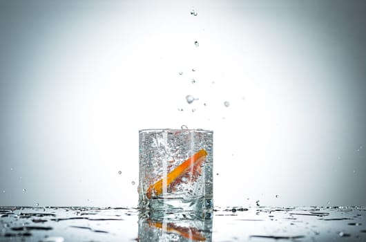The water splash in glass with grapefruit of gray studio color