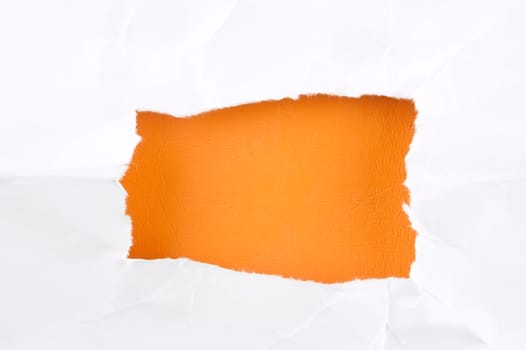 Sheet of torn paper againts orange background