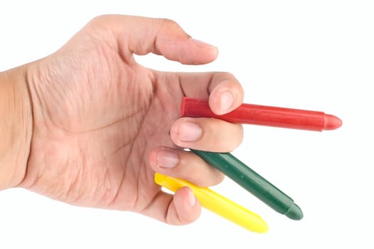 Hand holds orange, green, and yellow crayon on white background