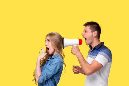 Man shouting in megaphones with woman at each other