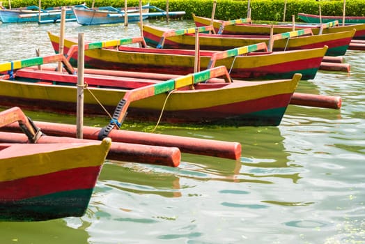 Colourful traditional Balinese fishing boats in line on the water