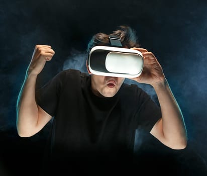 The man with glasses of virtual reality. Future technology concept. Black studio smoky background
