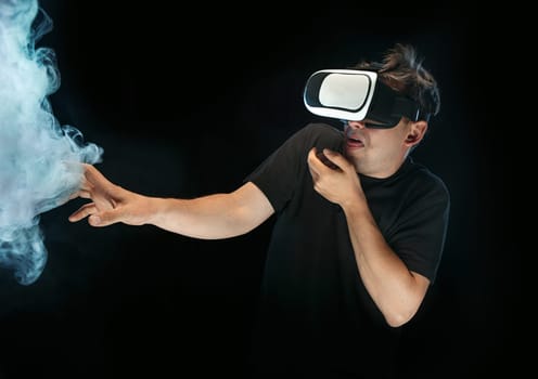 The man with glasses of virtual reality. Future technology concept. Black studio smoky background