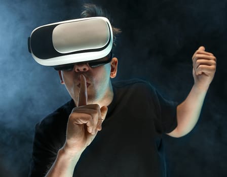 The man with glasses of virtual reality. Future technology concept. Black studio smoky background