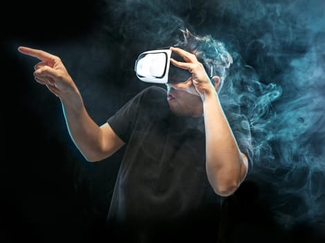 The man with glasses of virtual reality. Future technology concept. Black studio smoky background