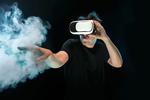 The man with glasses of virtual reality. Future technology concept. Black studio smoky background