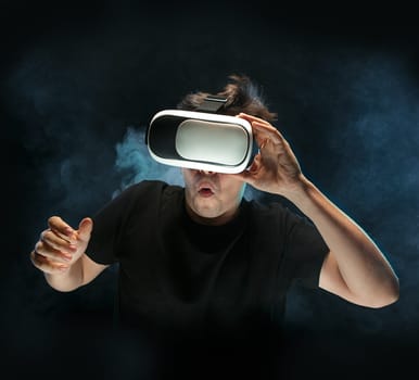 The man with glasses of virtual reality. Future technology concept. Black studio smoky background
