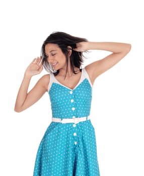A smiling gorgeous young woman standing waist up in a blue dress.with hands on her head, smiling, isolated for white background..
