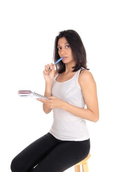 A brunette woman sitting and talking nots with a blue pen in.closeup, isolated for white background..