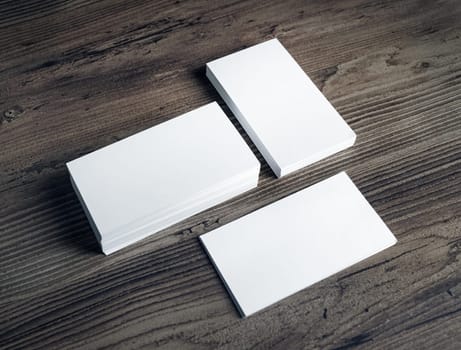 Photo of blank white business cards on vintage wooden table background. Mock up for ID. Blank template for branding identity.