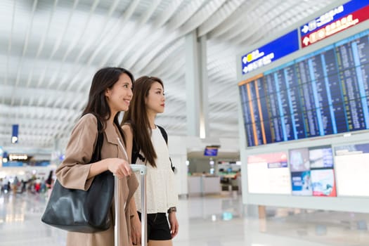 Friends go travel and looking at the information board