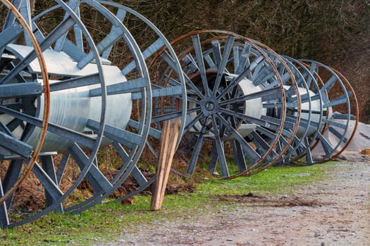 Empty large metal cable rolls for storing data cables.