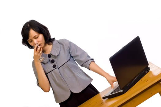 Beautiful asian business woman celebrating her success with wine in front of her computer
