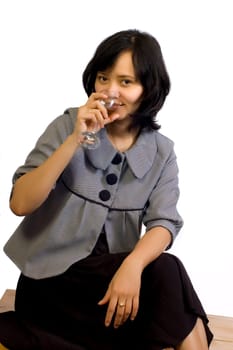 Young beautiful asian business woman celebrating her success with wine and sit on the table