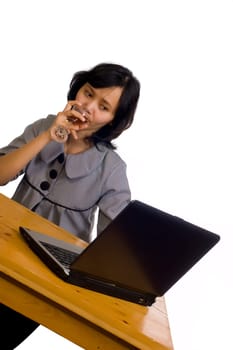 Beautiful asian business woman celebrating her success with wine in front of her computer