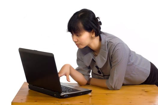 Beautiful asian business woman looking serious at her laptop on white background