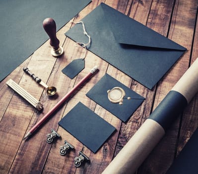 Black stationery mockup. Blank paperwork template for designers. Responsive design mockup on vintage wood background.