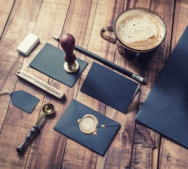 Photo of blank black vintage stationery elements on wood table background. Responsive design mockup. ID template.