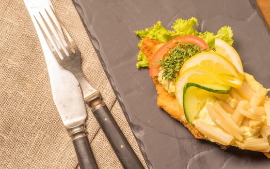 Danish specialties and national dishes, high-quality open sandwich, served on a plate ready for eating. fish fillet and garnished with remoulade and lemon