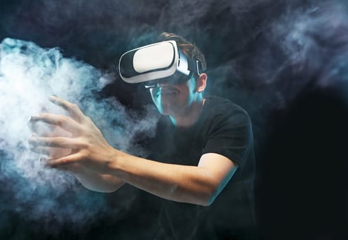 The man with glasses of virtual reality. Future technology concept. Black studio smoky background