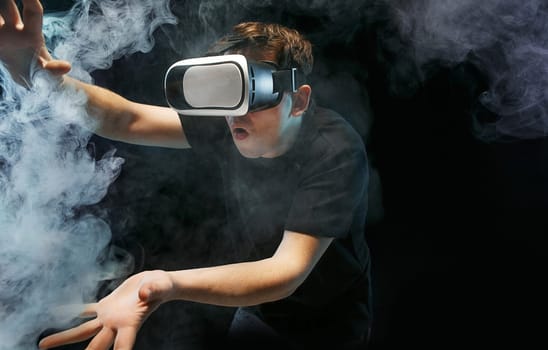 The man with glasses of virtual reality. Future technology concept. Black studio smoky background