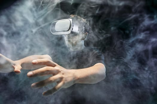 The man with glasses of virtual reality. Future technology concept. Black studio smoky background