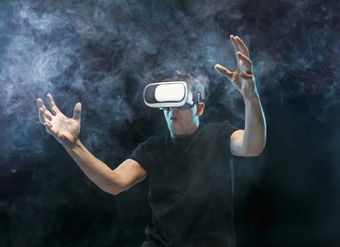 The man with glasses of virtual reality. Future technology concept. Black studio smoky background