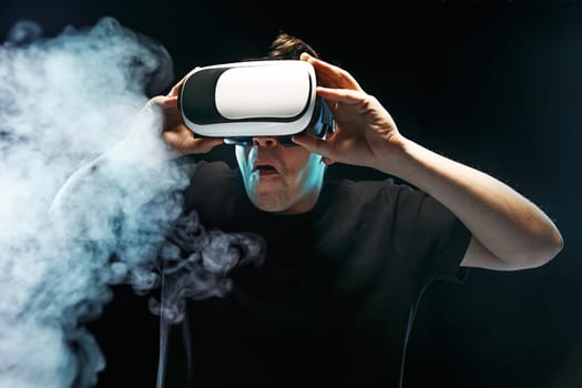 The man with glasses of virtual reality. Future technology concept. Black studio smoky background