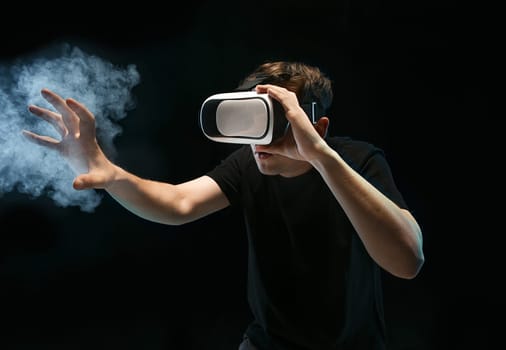 The man with glasses of virtual reality. Future technology concept. Black studio smoky background