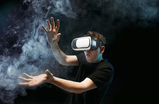 The man with glasses of virtual reality. Future technology concept. Black studio smoky background