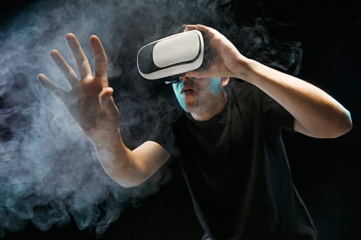The man with glasses of virtual reality. Future technology concept. Black studio smoky background