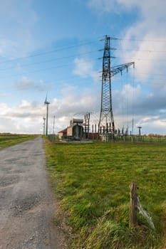 Landscape view in East Frisia with wind turbines,substation and high-voltage mast in the Abernd twilight.