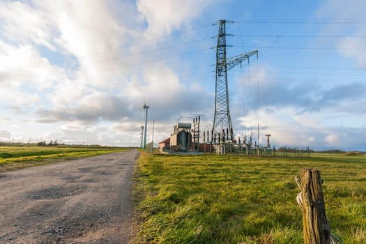 Landscape view in East Frisia with wind turbines,substation and high-voltage mast in the Abernd twilight.