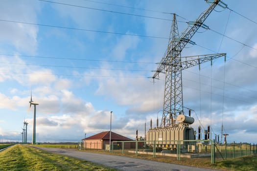 Landscape view in East Frisia with wind turbines,substation and high-voltage mast in the Abernd twilight.