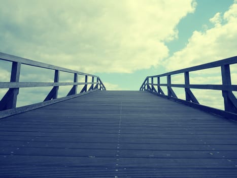 Wooden bridge into the sky with cloudy horizon, vintae style